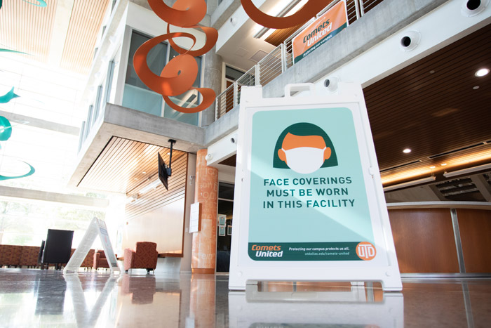 A sign in the Student Services Building that reads, face coverings must be worn in this facility. 