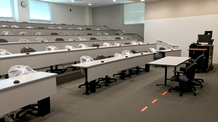 A classroom with seats marked off for social distancing. 