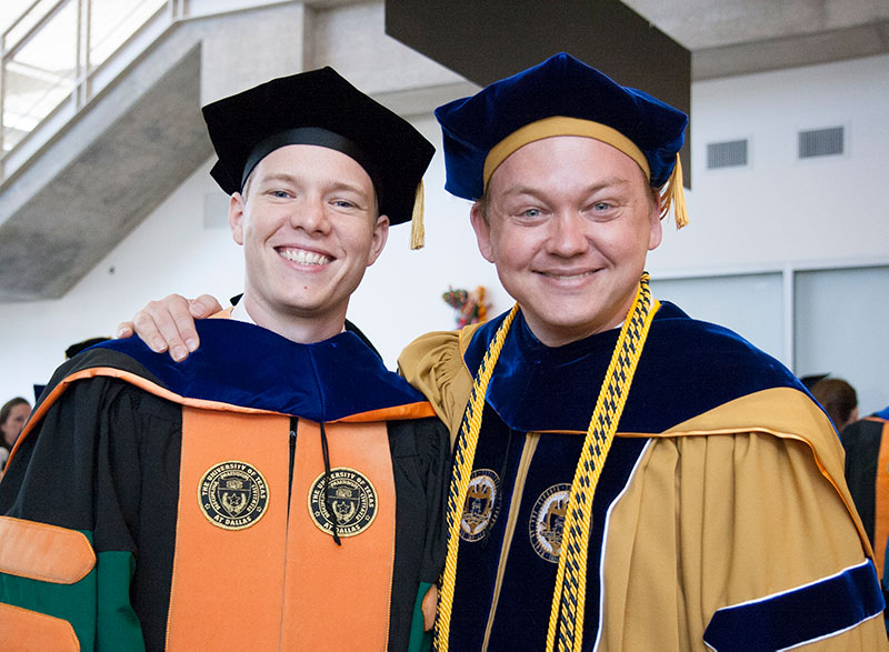 Reeder and Voit in commencement regalia