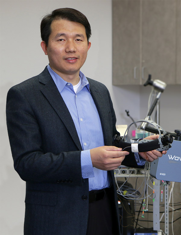 Dr. Jun Wang holds prototype device in his lab