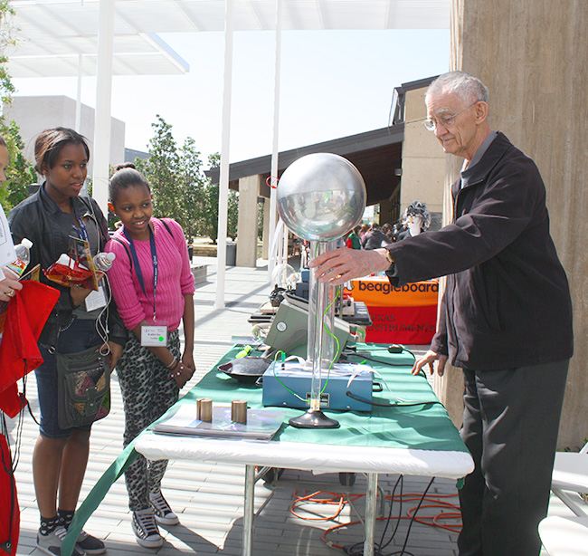 Dr. John Hoffman showing students his booth during the Sally Ride Festival.